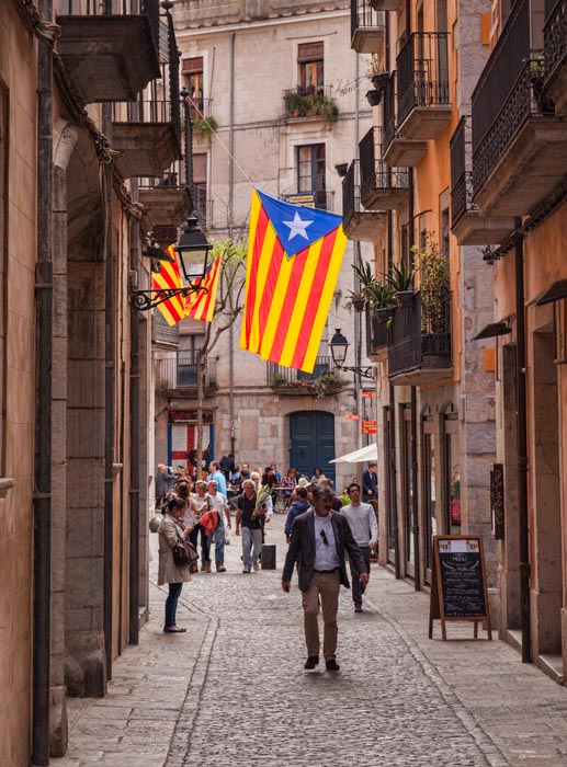 Flag of Catalonia flying in a back street of Girona, Catalonia, Spain.