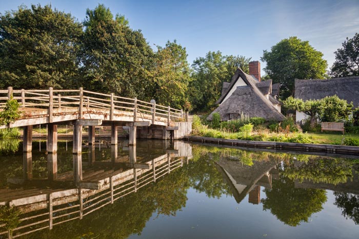 Flatford Bridge and Bridge Cottage on the River Stour in Dedham Vale, Suffolk, England.