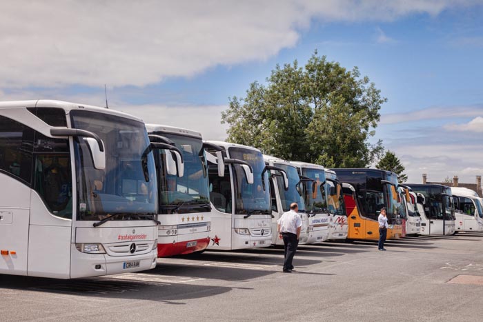 Tour coaches lined up in the Cotswold village of Bourton-on-the-Water, Gloucestershire, England