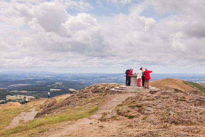 Group of tourists at the topograph on the summit of the Worcestershire Beacon, Worcestershire, England