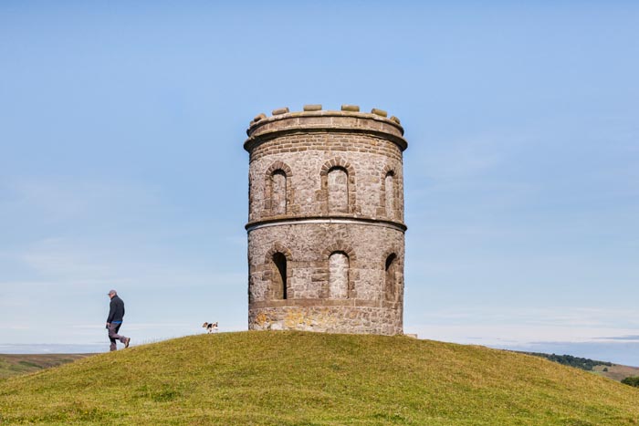 Man walking his Jack Russell terrier dog at Solomon's Temple, Grin Low and Buxton Country Park, Buxton, Derbyshire, England