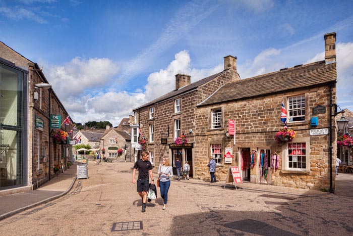 Young couple chatting and walking through Portland Sqaure, Bakewell, Derbyshire, England