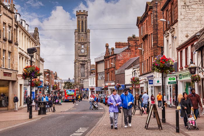 A busy shopping day in High Street, Ayr, South Ayrshire, Scotland. The clock tower is the Wallace Tower.
