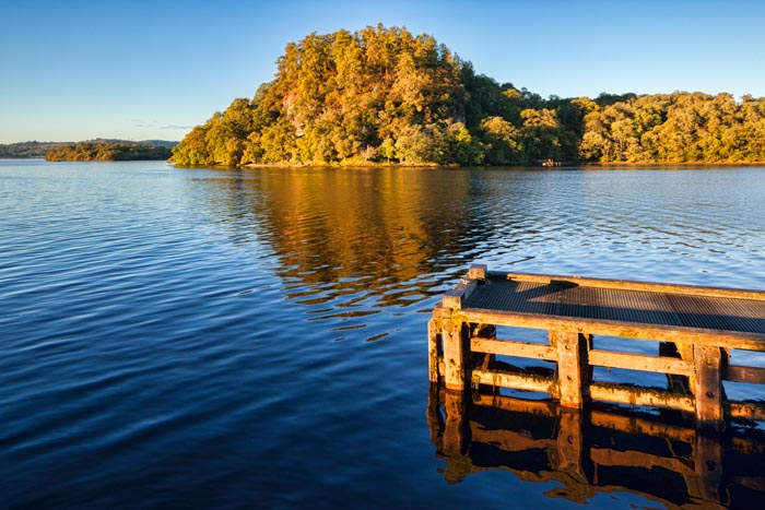 Jetty and island in autumn on Loch Lomond, Stirling, Loch Lomond and Trossachs National Park,Scotland, UK.