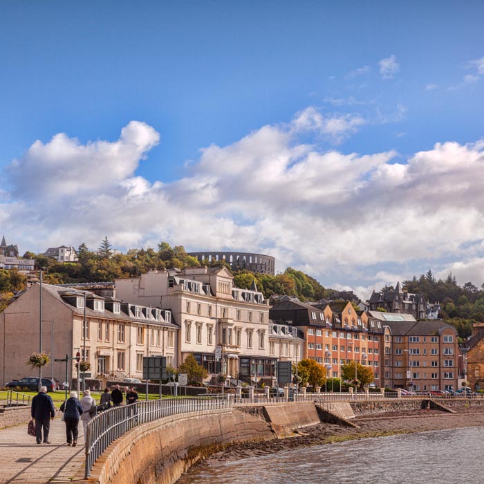 Houses and apartments on the promenade at Oban, with McCaigs Tower on the skyline, Oban, Argyll and Bute, Scotland, UK.