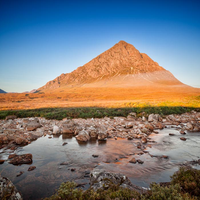 Autumn sunrise at Buachaille Etive Mor reflected in the Coupall River, Glencoe, Lochaber, Highlands, Scotland, UK.
