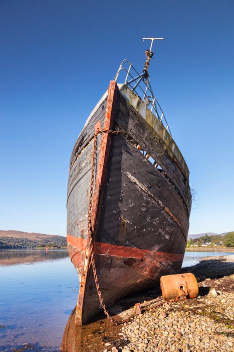 Old fishing boat washed up on the shores of Loch Linne, Fort William, Highland, Scotland, UK