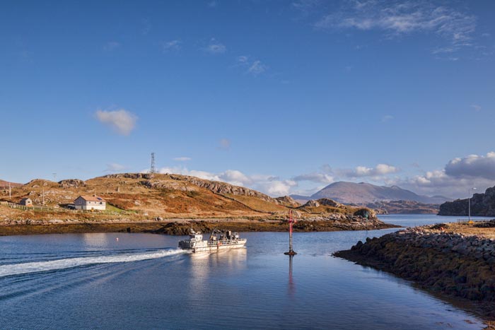 Fishing vessel leaving the harbour of Kinlochbervie, a fishing port in Sutherland, Scotland, UK.