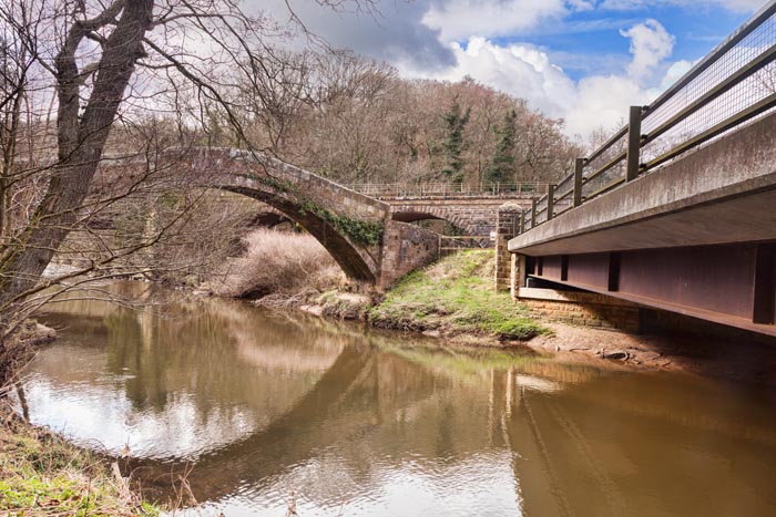 The Three Bridges at Glaisdale, North Yorkshire, England, UK - the ancient packhorse bridge known as the Beggars Bridge, the railway bridge, and the modern road bridge.