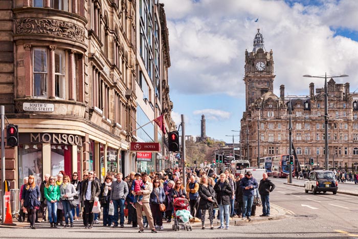 Crowd of people waiting to cross the road in Princes Street, Edinburgh, Scotland, UK