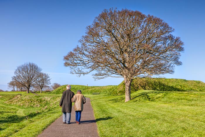 Senior couple walking the ramparts at Berwick-upon-Tweed on a bright spring day, Northumberland, England, UK