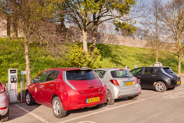 Electric cars being recharged beneath the city walls of York, North Yorkshire, England, UK