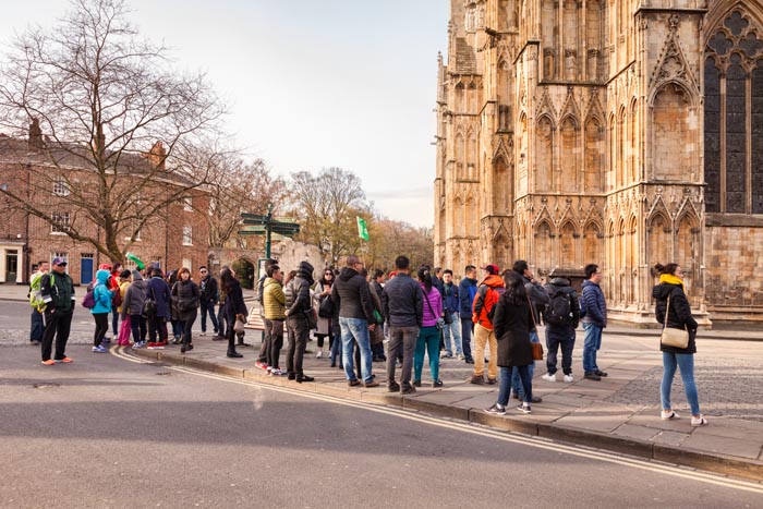 Large group of Asian tourists at York Minster, North Yorkshire, England, UK