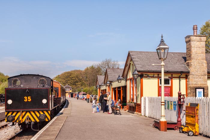 People waiting on the platform at Bolton Abbey Station as  0-6-0 Austerity Class Saddle Tank Engine arrives, showing its back end, Yorkshire Dales National Park, North Yorkshire, England, UK