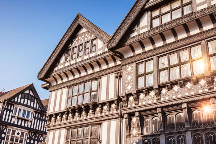 Black and white buildings in Chester, with beautiful clear blue sky and sunlight reflecting in windows, Cheshire, England, UK