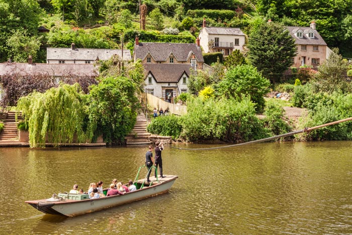 People crossing the River Wye on the ancient Hand Ferry at Symonds Yat, Gloucestershire, England, UK