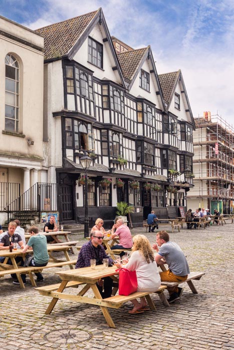 People sitting outside the Llandoger Trow, which dates from 1664, now a Brewer's Fayre pub in King Street, Bristol, England, UK.