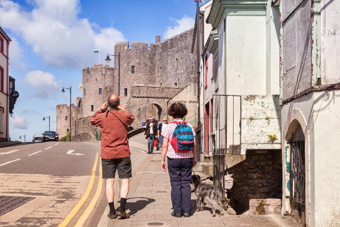 Visitor photographing the entrance to Pembroke Castle on Westgate Hill, Pembrokeshire, Wales,UK.