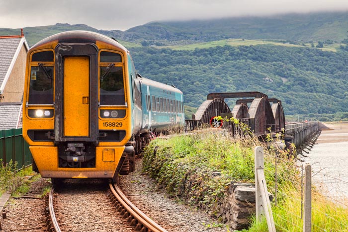 Diesel Multiple Unit of the Cambrian Coastal Railway, having just crossed the Barmouth Viaduct, Gwynedd, Wales, UK