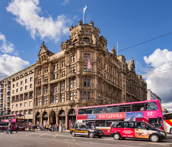 Busy street corner in Princes Street, Edinburgh, with Jenners Department Store, buses,taxis and people, Scotland, UK